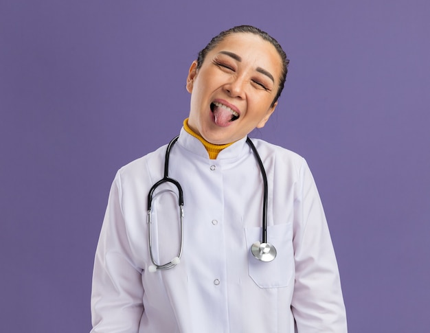 Free Photo | Young woman doctor happy and joyful sticking out tongue