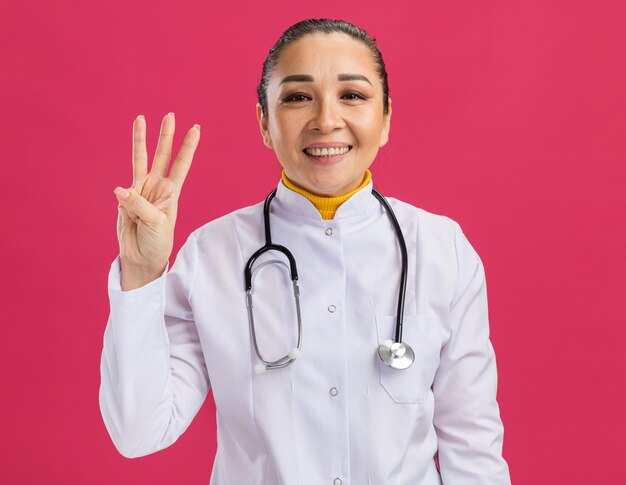 young woman doctor     happy and positive showing number three with fingers