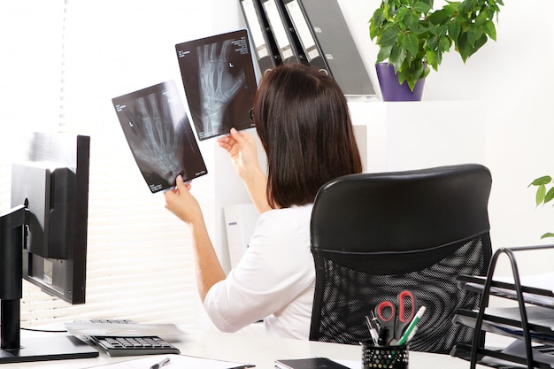 Young woman doctor is looking at xray