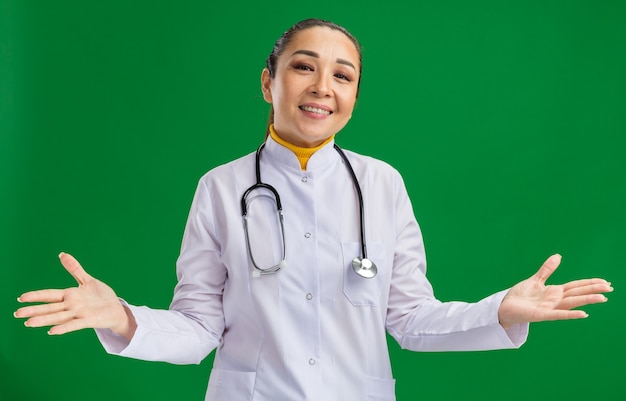 Free photo young woman doctor     smiling spreading arms to the sides