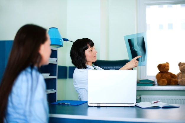 Young woman and doctor watching x-ray