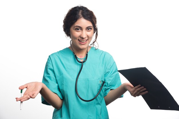 Young woman doctor with clipboard holding pen in her hand on white background. High quality photo