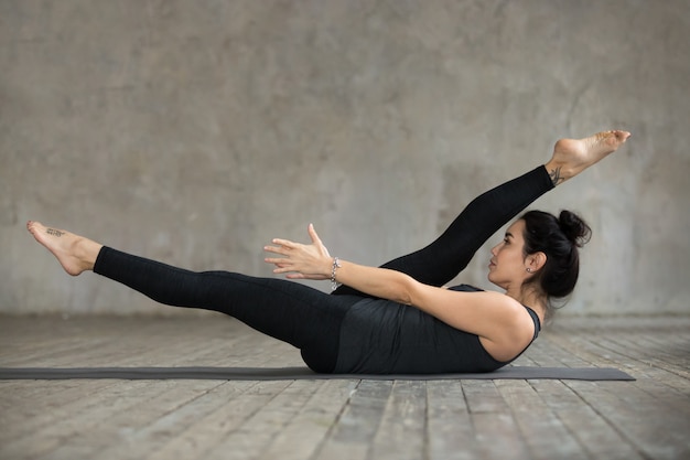 Бесплатное фото Молодая женщина делает упражнения на растяжку альтернативных ног