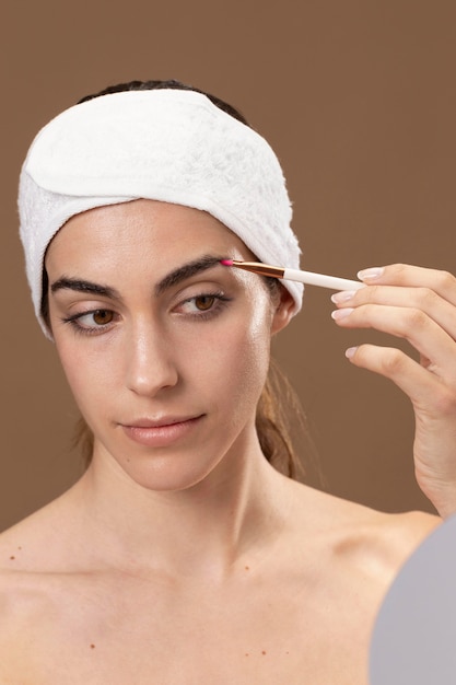 Free photo young woman doing a beauty treatment for herself