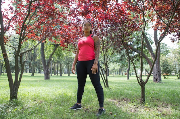 Бесплатное фото Молодая женщина делает упражнения в парке