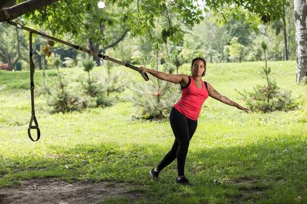 Молодая женщина делает упражнения в парке