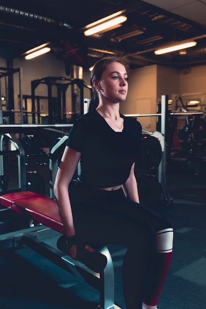 Free photo young woman doing exercise with dumbbell in fitness center