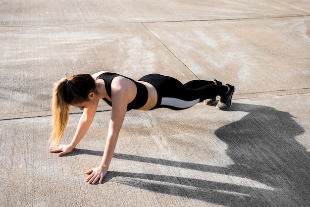 Young woman doing exercises at the street