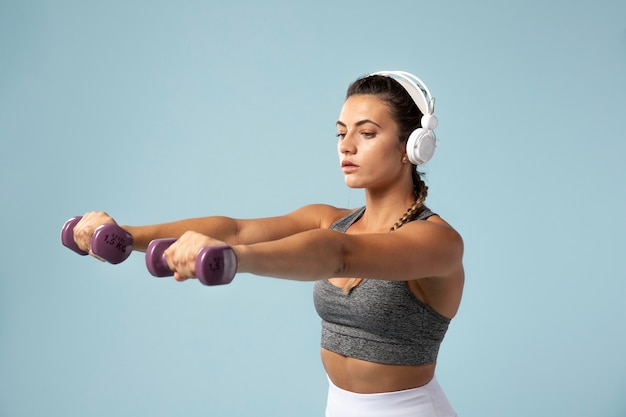 Young woman doing exercises with her headphones on