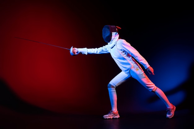 Young woman doing fencing in special equipment