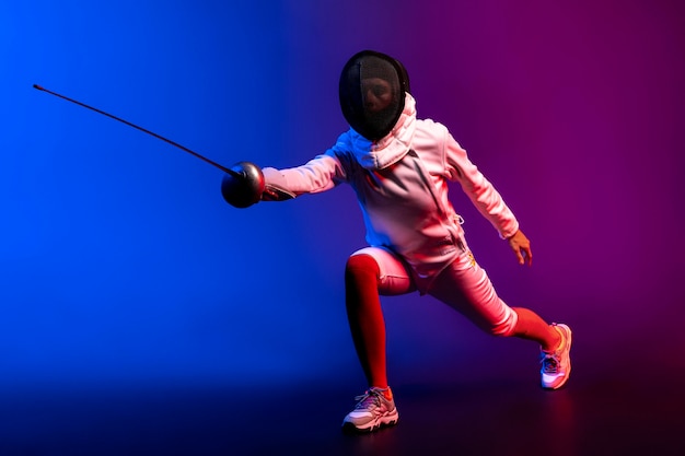 Free photo young woman doing fencing in special equipment