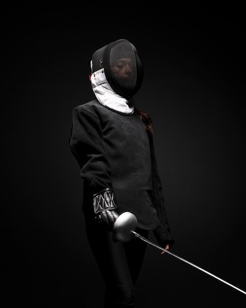 Free photo young woman doing fencing in special equipment