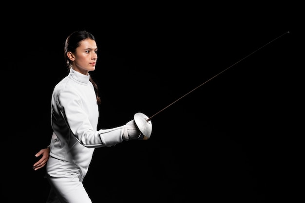 Free photo young woman doing fencing