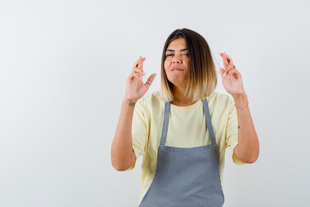 Young woman doing a good luck hand gesture on white background