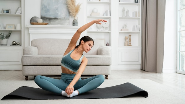 Young woman doing her workout at home on a fitness mat