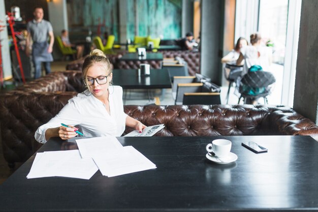 Free photo young woman doing paperwork in restaurant