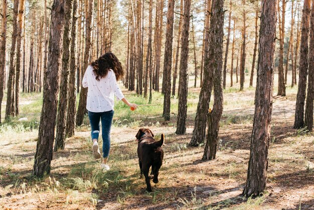 彼女の犬と一緒にピクニックをしている若い女性