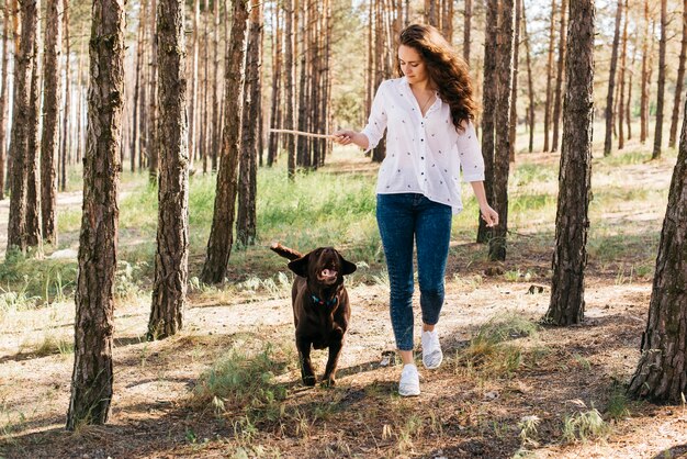 彼女の犬と一緒にピクニックをしている若い女性