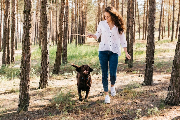 彼女の犬と一緒にピクニックをしている若い女性