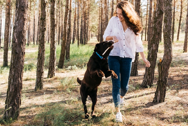 彼女の犬と一緒にピクニックをしている若い女性