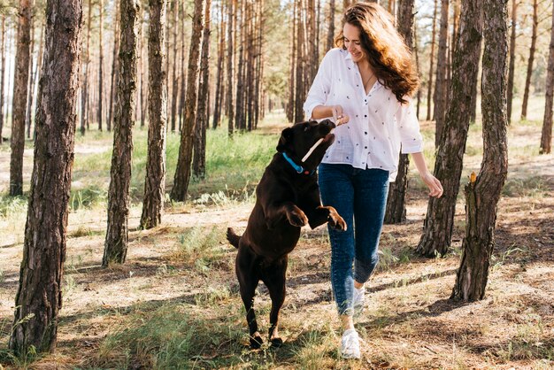 彼女の犬と一緒にピクニックをしている若い女性