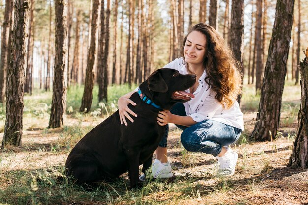 彼女の犬と一緒にピクニックをしている若い女性