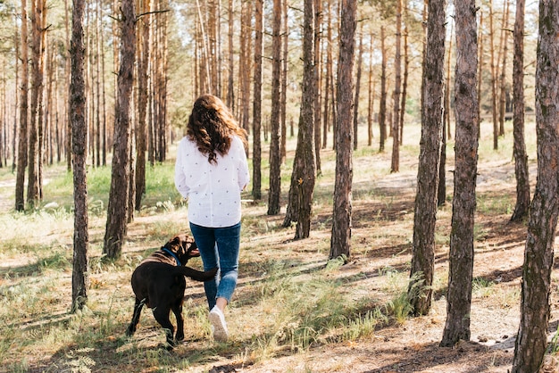 彼女の犬と一緒にピクニックをしている若い女性