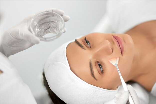 Young woman doing procedure for face in beautician