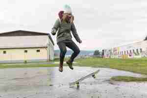 Foto gratuita giovane donna facendo acrobazie di skateboard