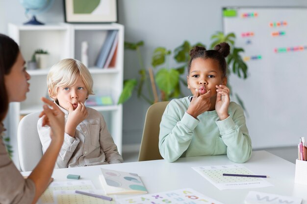 Young woman doing speech therapy with children