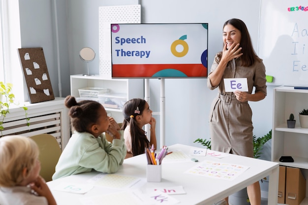 Young woman doing speech therapy with kids