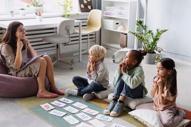 Young woman doing speech therapy with kids