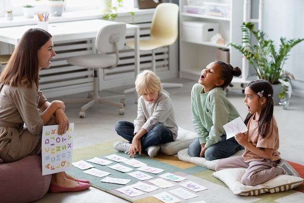 Young woman doing speech therapy with kids