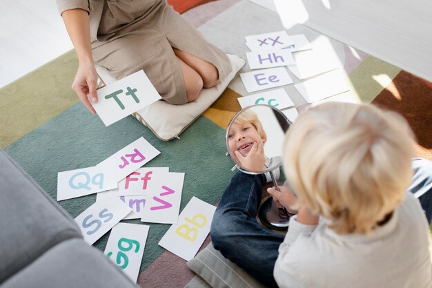 Young woman doing speech therapy with a little blonde boy