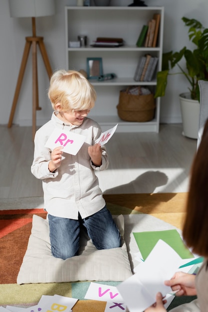 Young woman doing speech therapy with a little boy