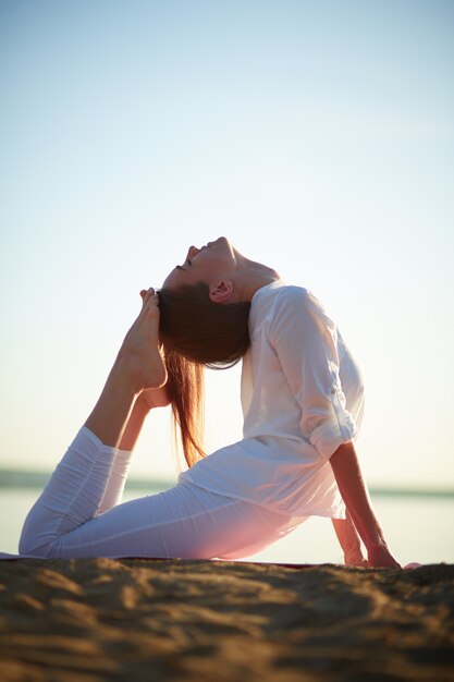 Young woman doing yoga exercise outdoors