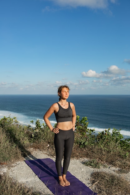 Giovane donna che fa yoga all'aperto con incredibile vista posteriore. bali. indonesia.