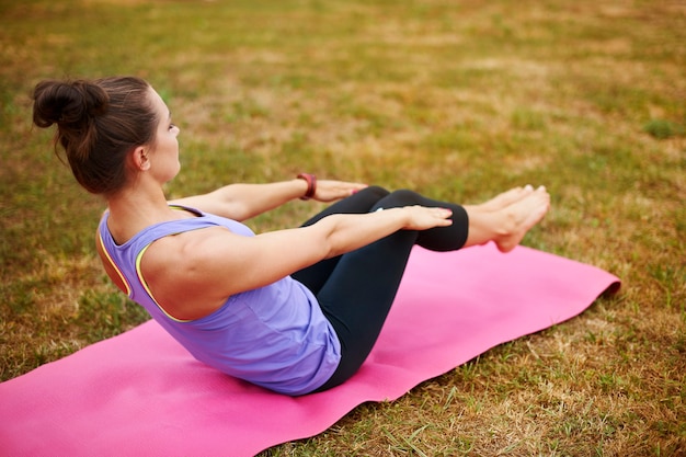 Young woman doing yoga in the park. It is not easy to keep yourself fit