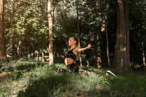 Foto gratuita giovane donna che fa yoga nel parco