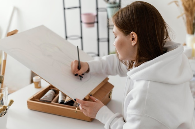 Young woman drawing on canvas