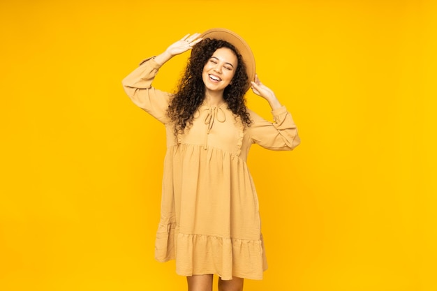 Young woman in dress on yellow background