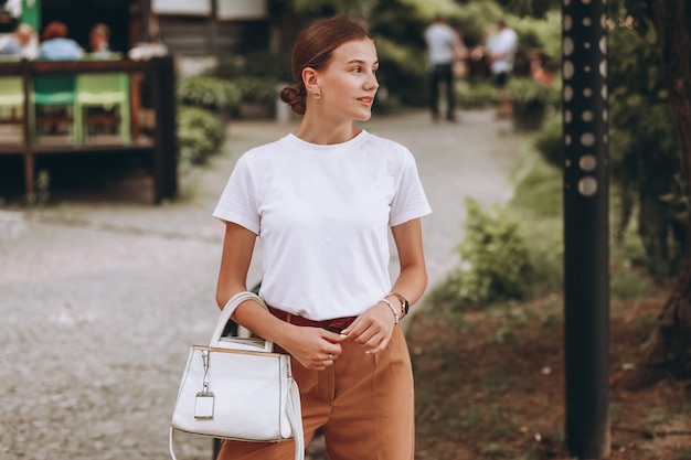 Young woman dressed casual outside in city park