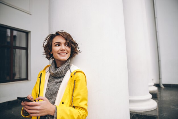 Young woman dressed in raincoat walking outdoors