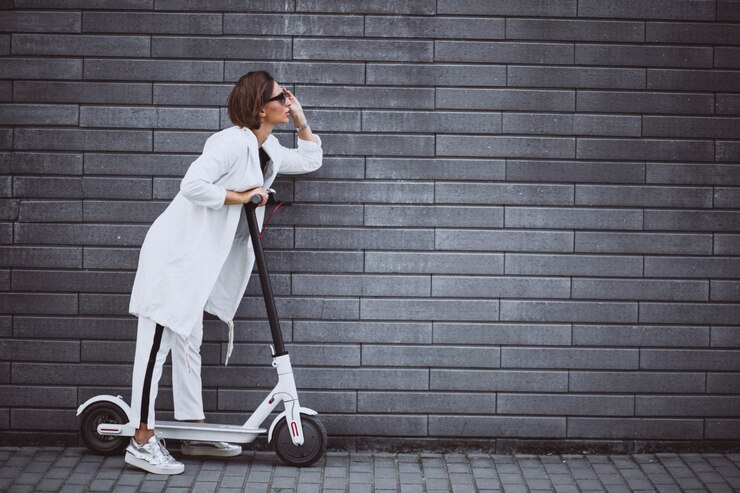 Free Photo young woman dressed in white riding scooter