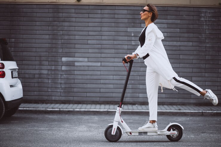 Free Photo young woman dressed in white riding scooter