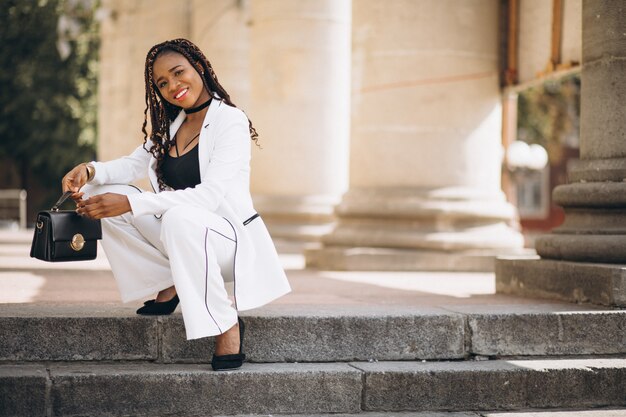 Young woman dressed in white sitting on stairs