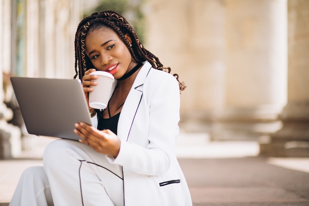 Free photo young woman dressed in white using laptop