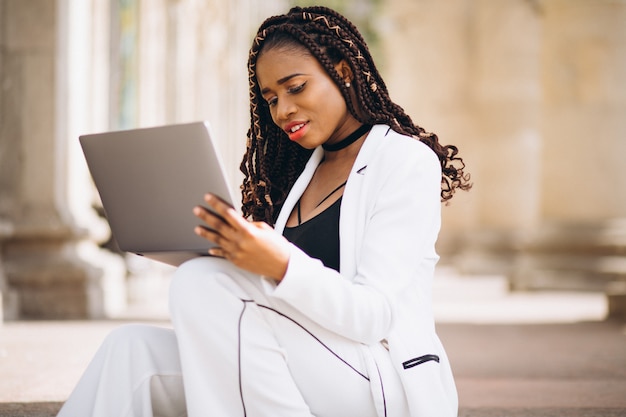 Young woman dressed in white using laptop