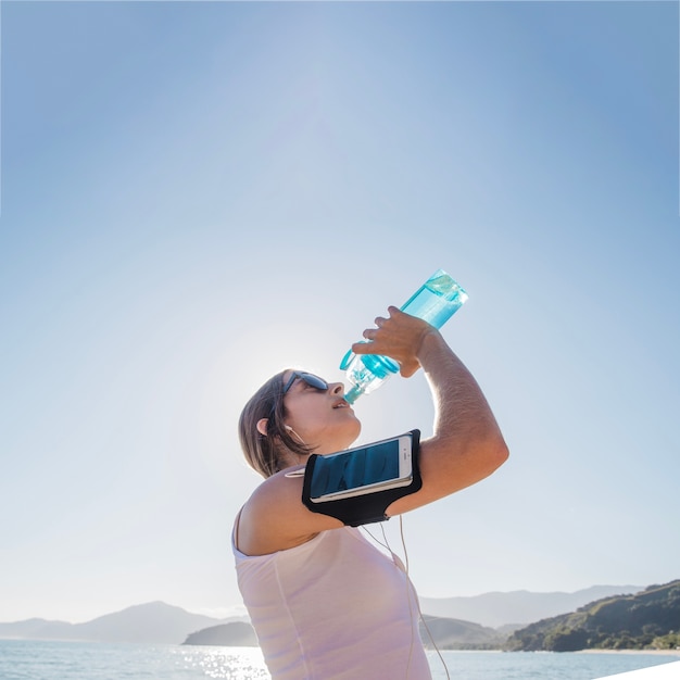 Young woman drinking after training