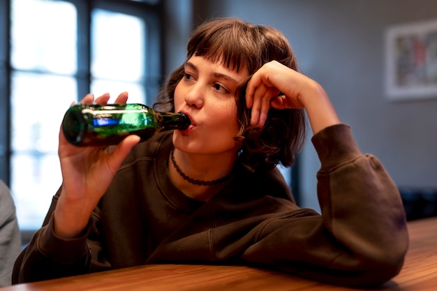 Молодая женщина пьет пиво в одиночестве